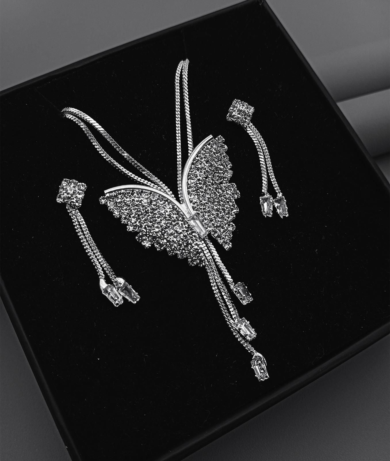 Butterfly-shaped jewelry set on a black background