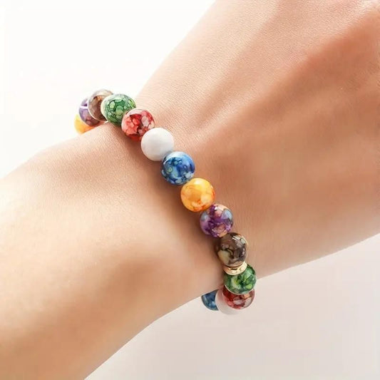 Multicolored beaded bracelet on a wrist against a neutral background